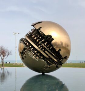 Bronze spherical sculpture lying on water, nicknamed 